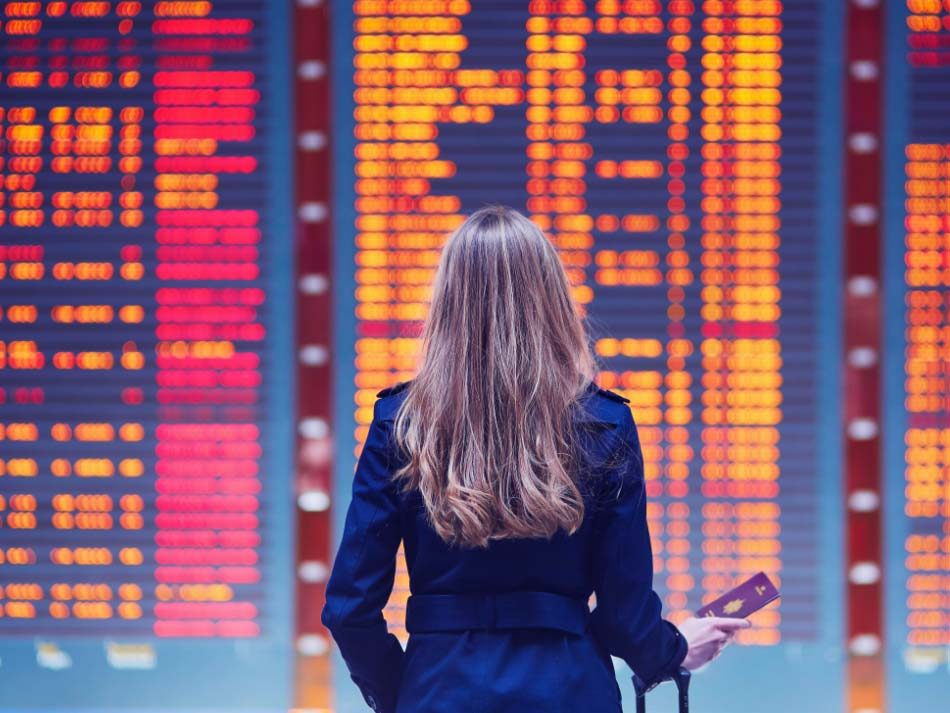 Image of woman standing looking at a station timetable board