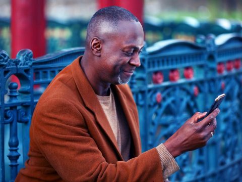 A man outside looking at his mobile device