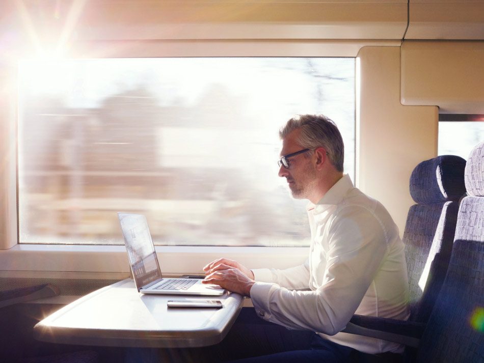Man working on a laptop on a train
