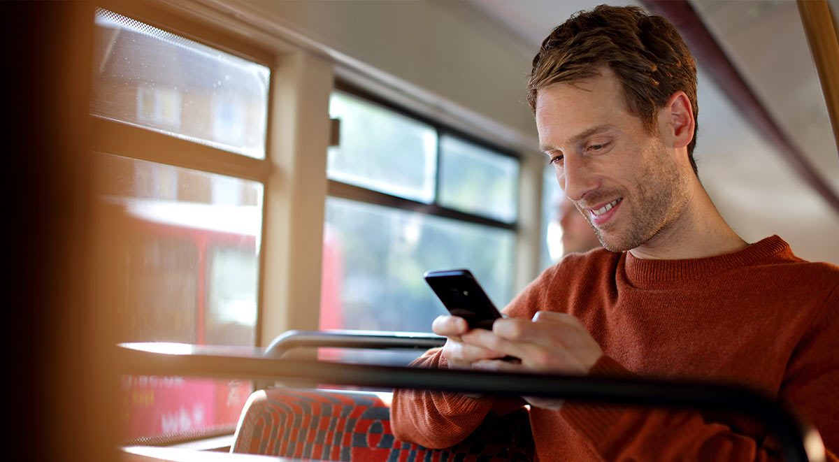 Man using mobile device on a bus